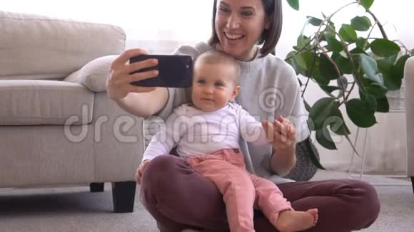 妈妈和宝贝女儿一起用手机自拍视频的预览图