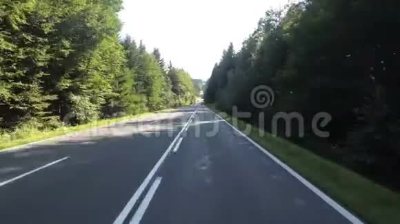 摩托车手骑在一条经过奥地利森林的风景道上第一人观点视频的预览图