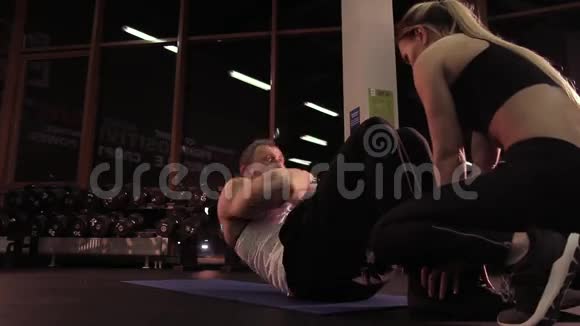 健身教练向客户展示锻炼一名年轻女子重复锻炼视频的预览图