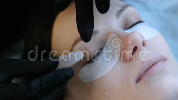 美容治疗美容师把卷发器贴在女人的眼皮上视频的预览图