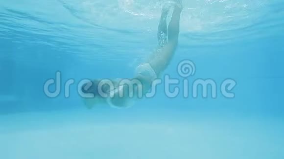 穿着泳装的迷人女人跳进游泳池游泳旋转视频的预览图