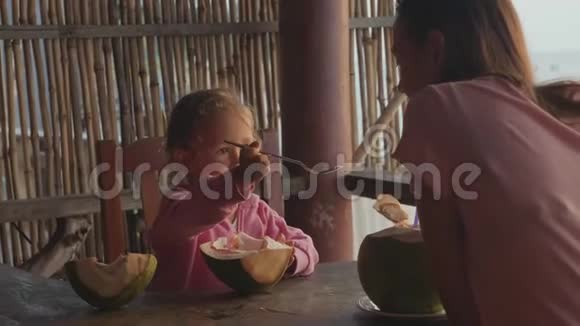 母女俩慢悠悠地坐在海景咖啡馆里手里拿着椰子视频的预览图