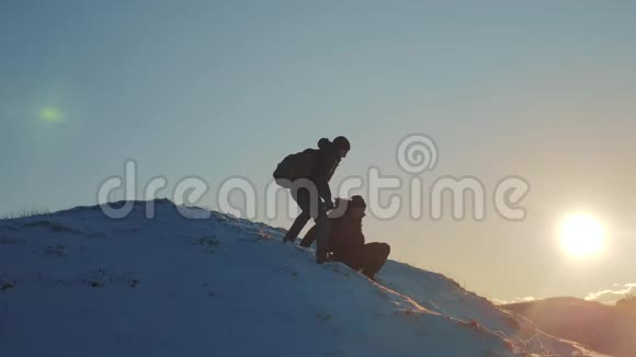 团队合作剪影商务旅行理念2两个徒步旅行者从登山者手中滑下来爬到山顶视频的预览图