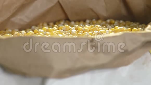 玉米从雄性手中掉进袋子里慢动作视频的预览图