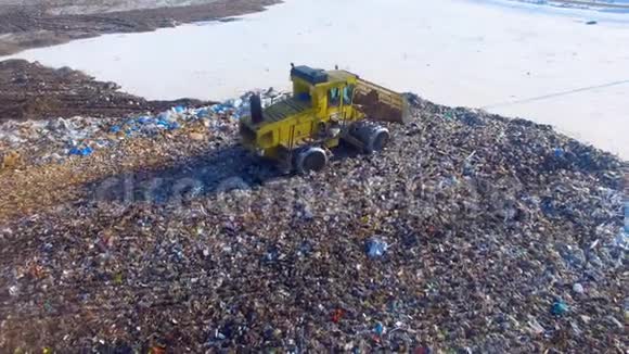 垃圾填埋场推土机在垃圾堆边移动视频的预览图