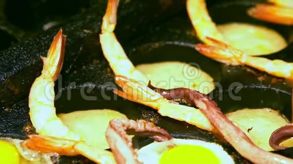 小贩用鱿鱼触须烹煮鹌鹑蛋的慢动作视频的预览图