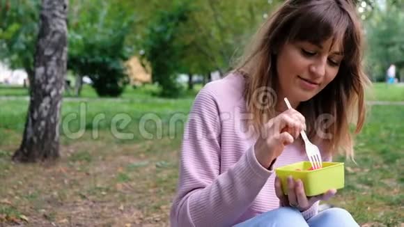一个年轻漂亮的女孩吃西瓜的照片看着镜头微笑着特写健康的生活方式视频的预览图