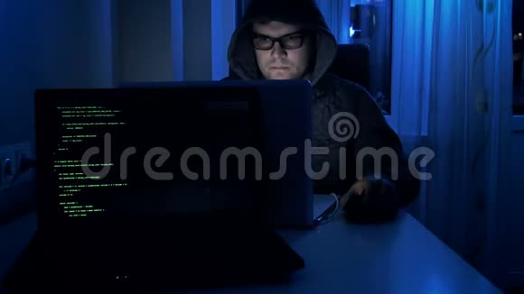 黑客在夜间工作时戴眼镜和头罩的4k镜头视频的预览图