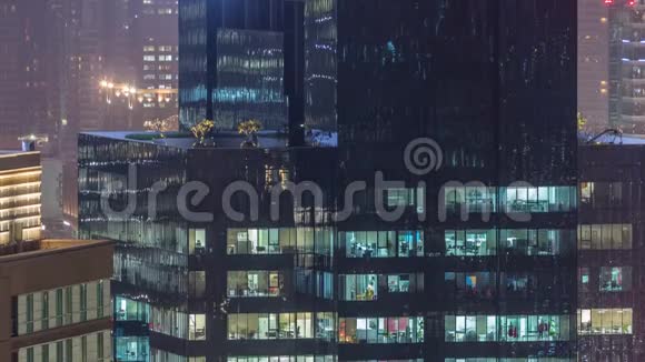 夜间城市环境下现代多层办公楼窗户的灯光视频的预览图