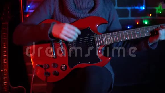 一个可爱的年轻女子正在砖墙附近的红色电吉他上弹奏视频的预览图