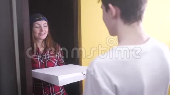 披萨外卖概念女人给那个十几岁的男孩送了一盒披萨慢动作视频快餐概念视频的预览图