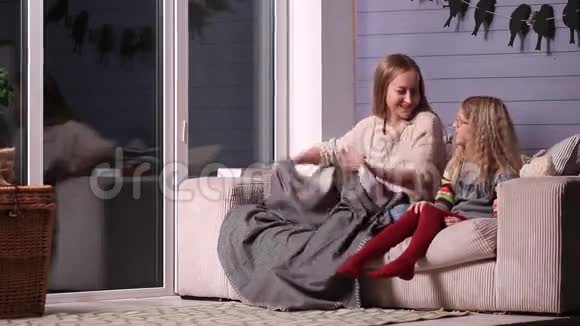 妈妈和女儿用毯子裹在沙发上视频的预览图