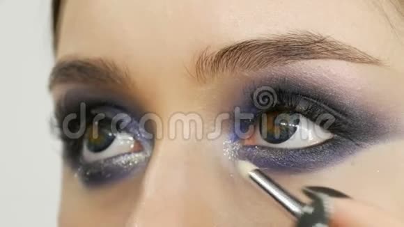 年轻漂亮的性感女孩模特让蓝色的晚上组成烟雾弥漫的眼睛和假睫毛多种颜色的眼睛视频的预览图