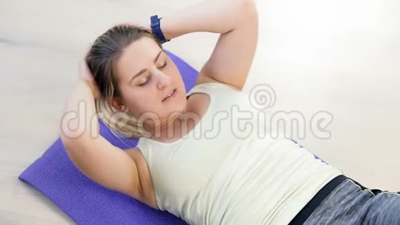 在家健身垫上做仰卧起坐的美女慢动作视频视频的预览图