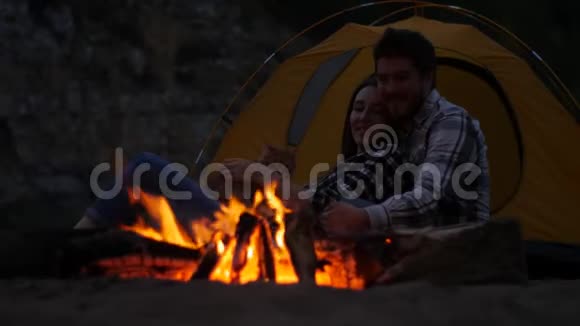 旅行和爱情的概念小可爱的一对在营地壁炉旁视频的预览图