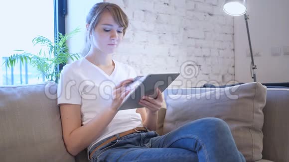 坐着的女人在平板电脑上的网上购物视频的预览图