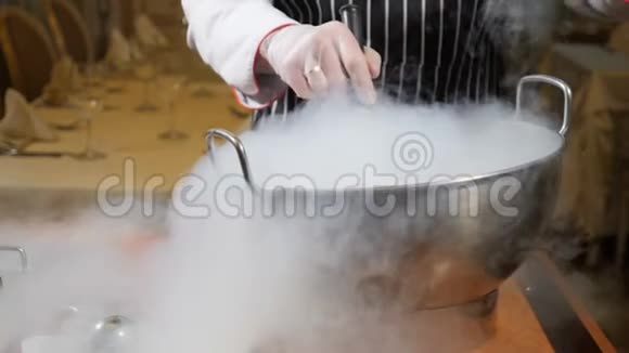 在餐馆做饭在工作的饼干职业厨师在手套里用干冰做甜点厨师倒水视频的预览图