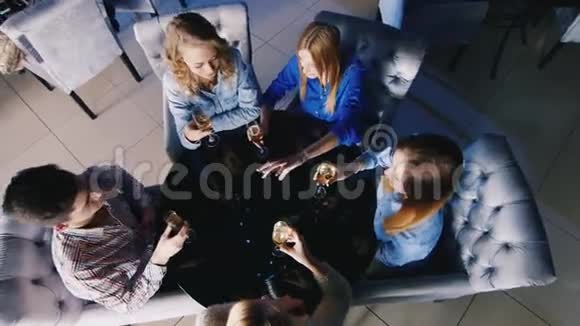 一群年轻人在咖啡馆或餐馆的桌子旁放松喝酒聊天从上面看视频的预览图