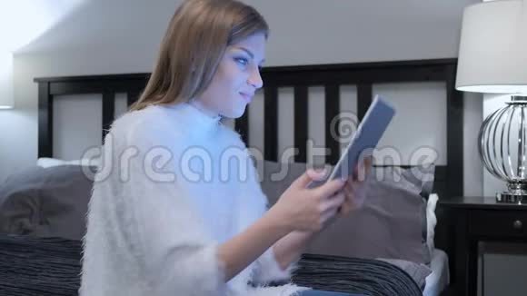 由女性在平板电脑上在线视频聊天卧室视频的预览图