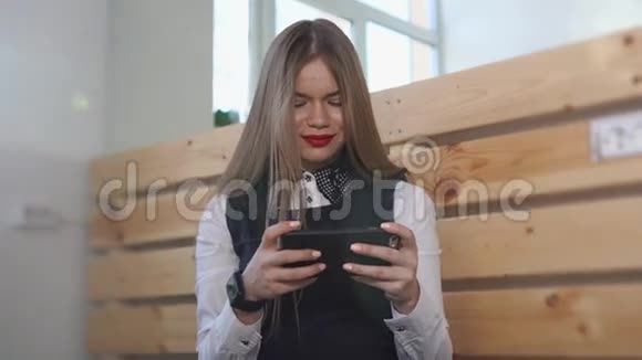年轻的商务女性看着手机手上拿着一只新的智能手表视频的预览图