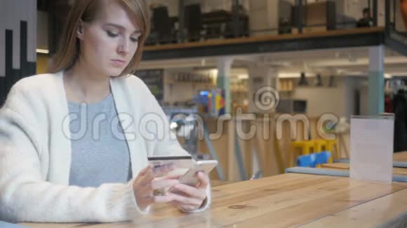 女性在网吧用智能手机购物付款视频的预览图