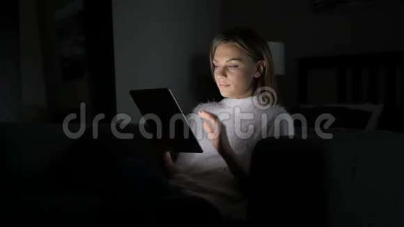 女性在平板电脑上进行夜间在线视频聊天视频的预览图
