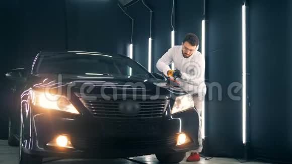 男工人正在擦一辆黑色汽车视频的预览图