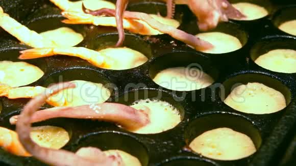 小贩用鱿鱼触须烹煮鹌鹑蛋的慢动作视频的预览图