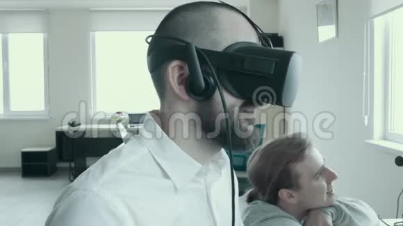 上班族在工作中使用虚拟现实眼镜一个戴着虚拟眼镜的秃头青年的特写镜头视频的预览图