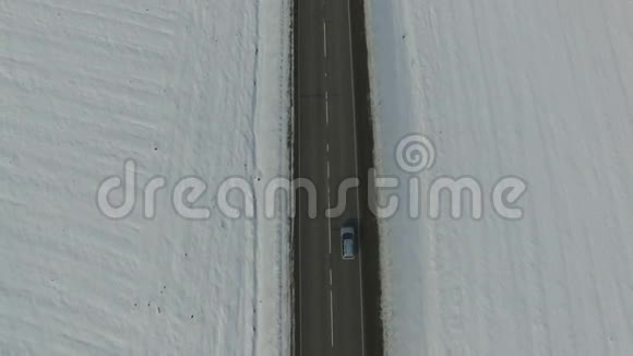 冬季阳光明媚的一天汽车在公路上行驶的空中镜头视频的预览图