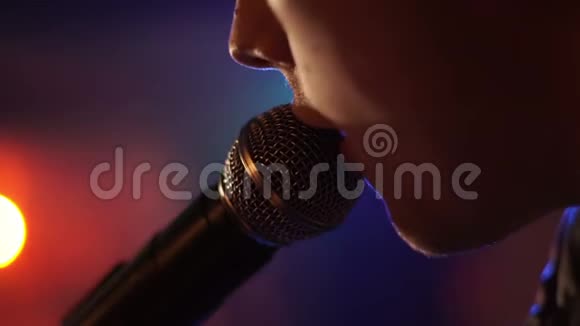 在摇滚音乐会舞台上表演时男子用麦克风演唱歌曲在音乐上接近摇滚歌星视频的预览图