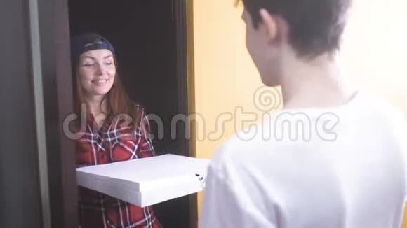 披萨外卖概念女人给那个十几岁的男孩送了一盒披萨慢动作录像快餐概念视频的预览图