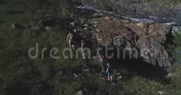 空中飞行游客的家人一个年轻的女人和男人带着孩子走在山上的一条小路上年轻的母亲视频的预览图