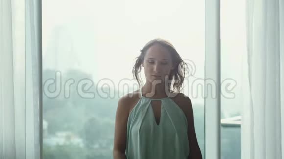 迷人的年轻女孩睡衣在气窗的背景上喷着一股香水的香味视频的预览图