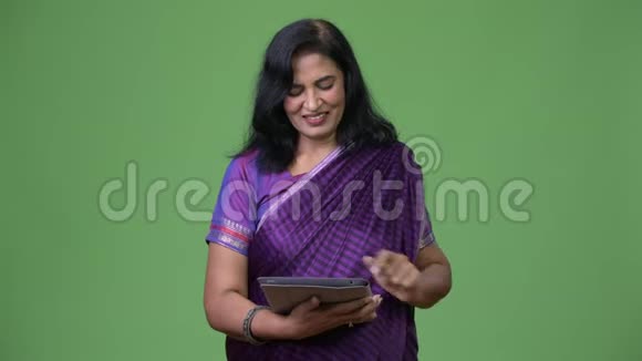 成熟快乐美丽印度女人用数码平板微笑视频的预览图