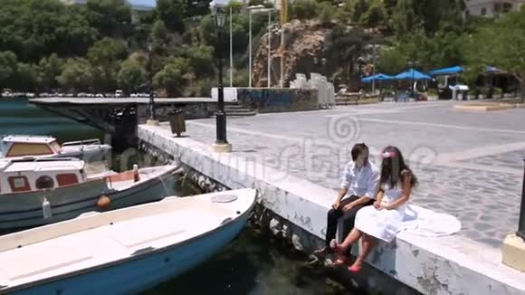 快乐的新婚夫妇坐在码头视频的预览图