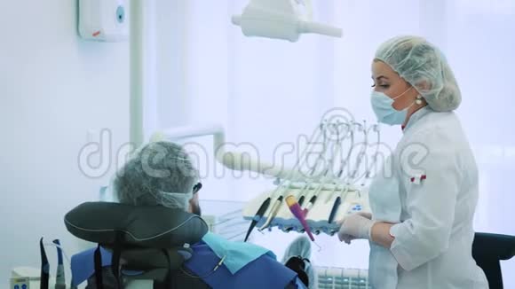 健康和牙科护理妇女在工作中担任牙医和医生与男性病人交谈讨论牙科治疗视频的预览图