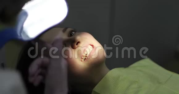 一位妇女正坐在牙医接待处的牙科椅上视频的预览图
