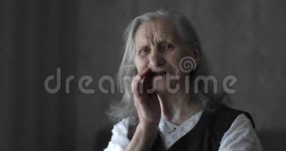 一位白发苍苍的老妇人看着摄像机说话视频的预览图