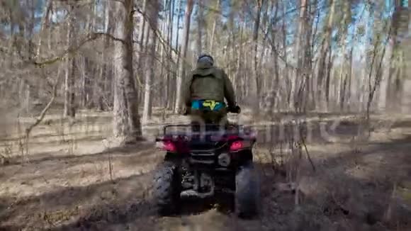 接近一个年轻的运动员操作粉红色的ATV站在上面穿过森林小径年轻的探险家视频的预览图