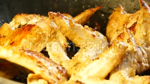 鸡翅用煎锅炒吃鸡肉的晚餐热油在煎锅里沸腾视频的预览图