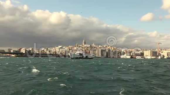 拍摄的加拉塔塔在前景游船与游客和海鸥背景上的游乐船视频的预览图