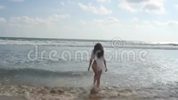 年轻漂亮的女孩在海边享受生活和乐趣快乐的女人站在海边视频的预览图