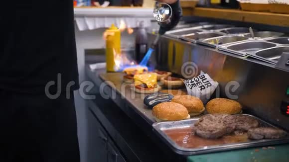 厨师融化纯素奶酪使用燃烧炉和制作汉堡在餐厅厨房4K慢动作视频的预览图