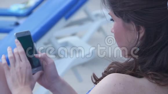 海滩上的年轻美女开始打电话聊天视频的预览图