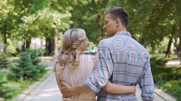 恋爱中的男女青年在夏日公园散步后景慢镜头视频的预览图