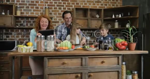 一家人一起做饭用的是平板电脑配方一家人有两个孩子在厨房准备食物视频的预览图