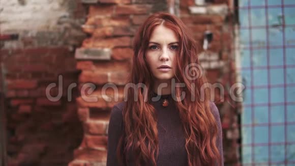 一个红发女孩的特写肖像有着神秘的表情雀斑女孩看镜头视频的预览图