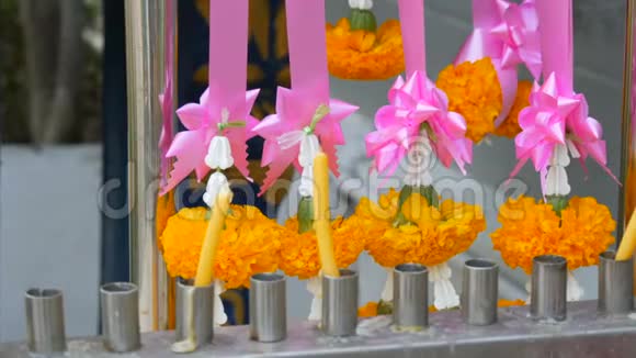 泰国传统佛教祭坛附近的蜡烛和鲜花视频的预览图