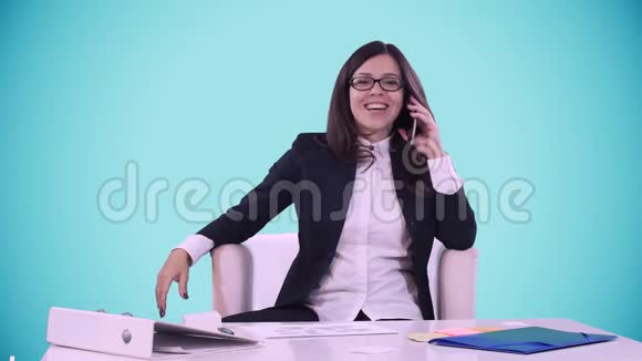 一位身穿商务服笑容满面的年轻黑发女子在镜头前露出大拇指她坐在办公桌后面的办公室里视频的预览图